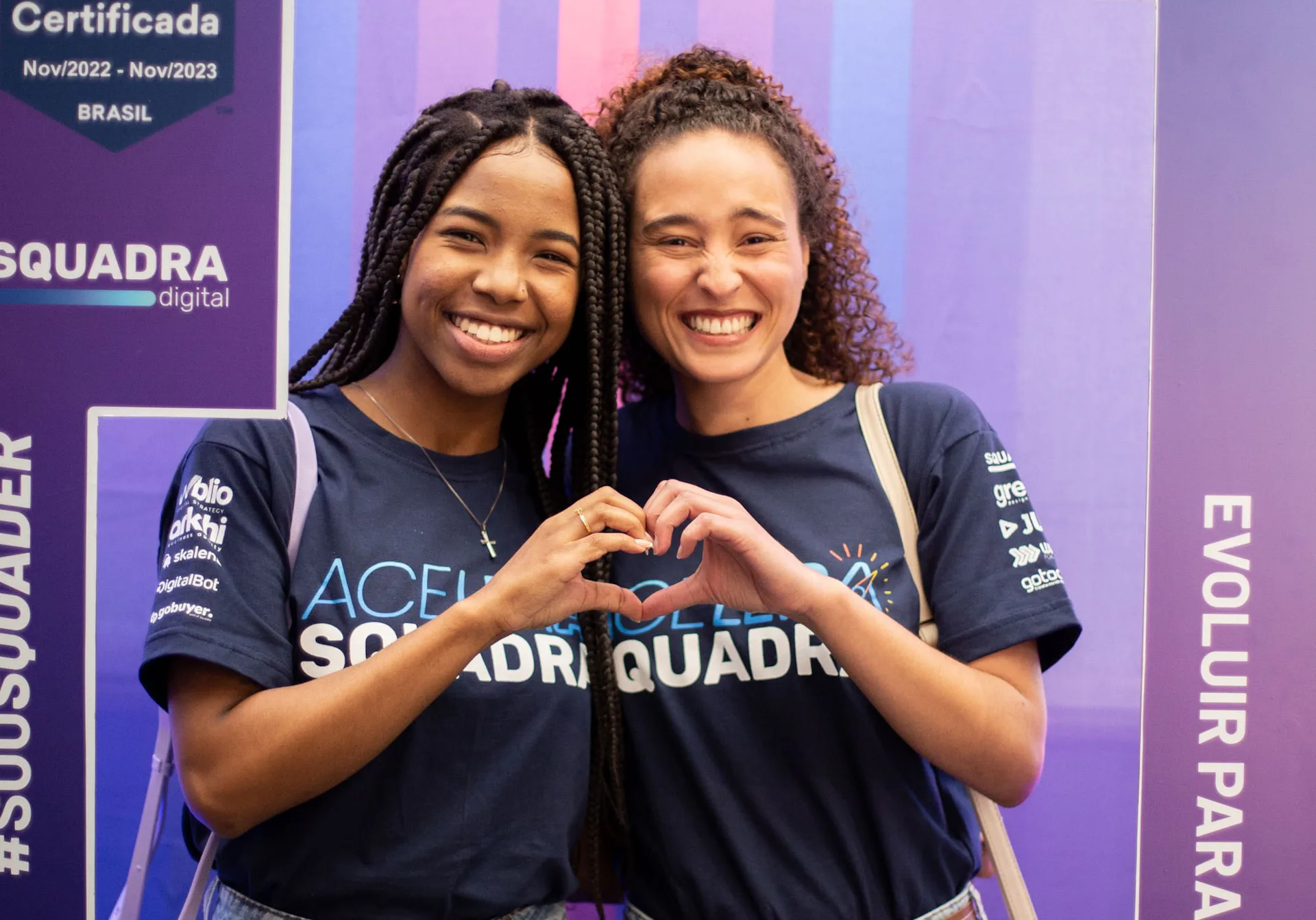 Duas Squaders fazendo um coração com as mãos.