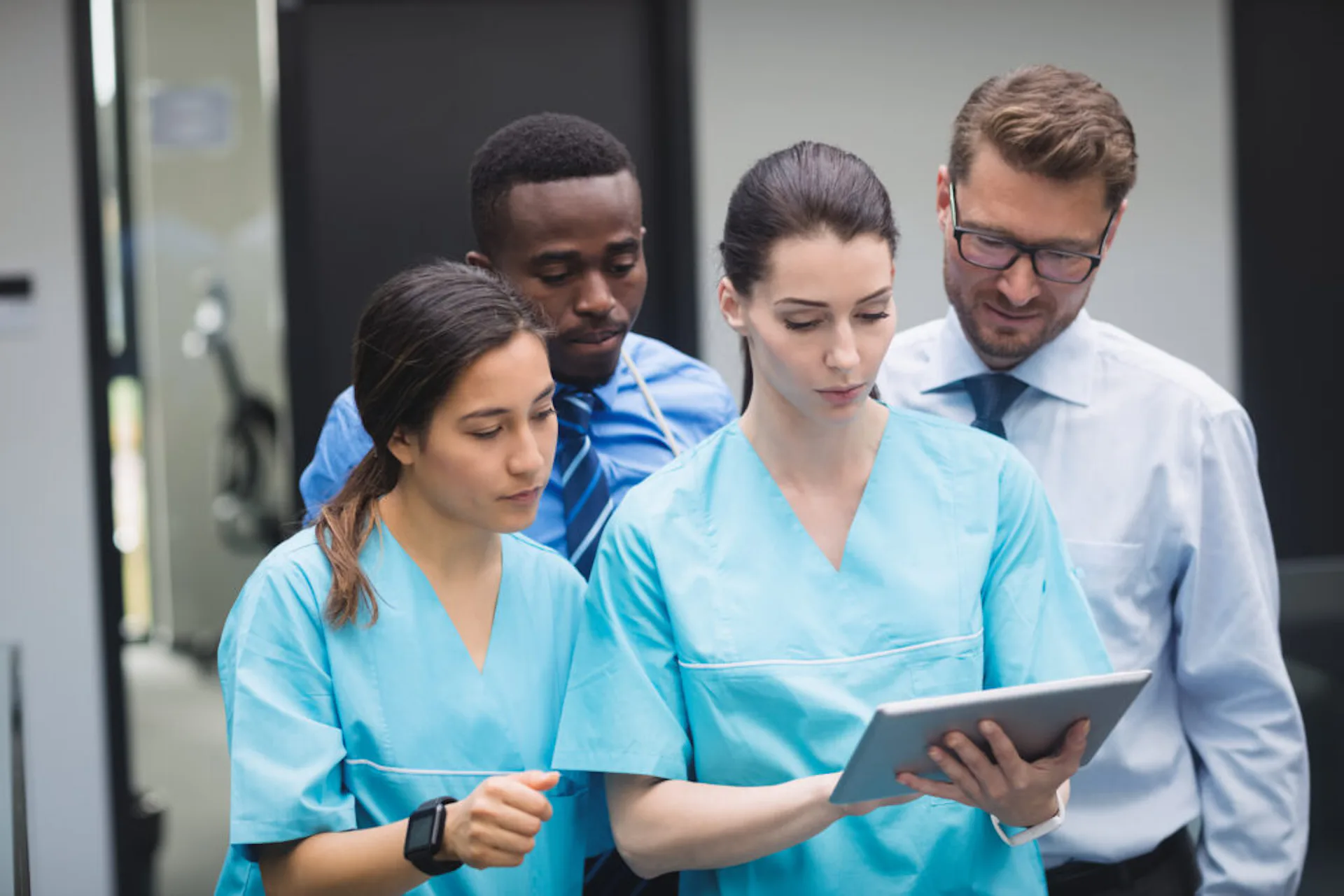 Médicos discutindo entre si olhando para um tablet