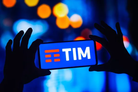 Imagem de uma pessoa segurando o celular com o logo da TIM.